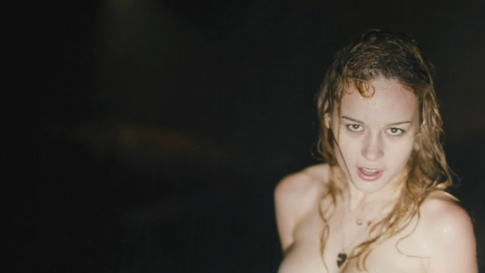 Then Brie Larson is seen topless and wet, as she stands on a road in the ra...